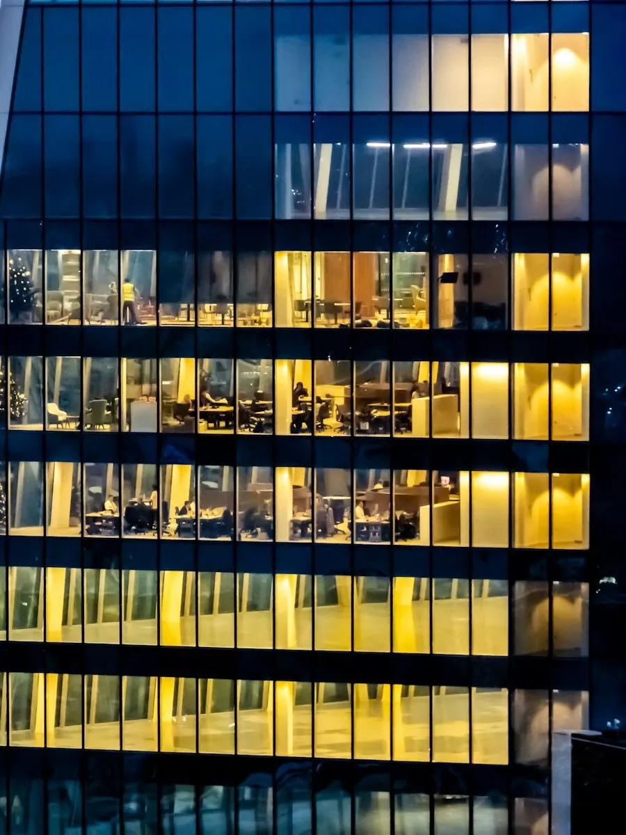 A tower at night, the lit offices standing out of the dark — the opportunities Q surfaces