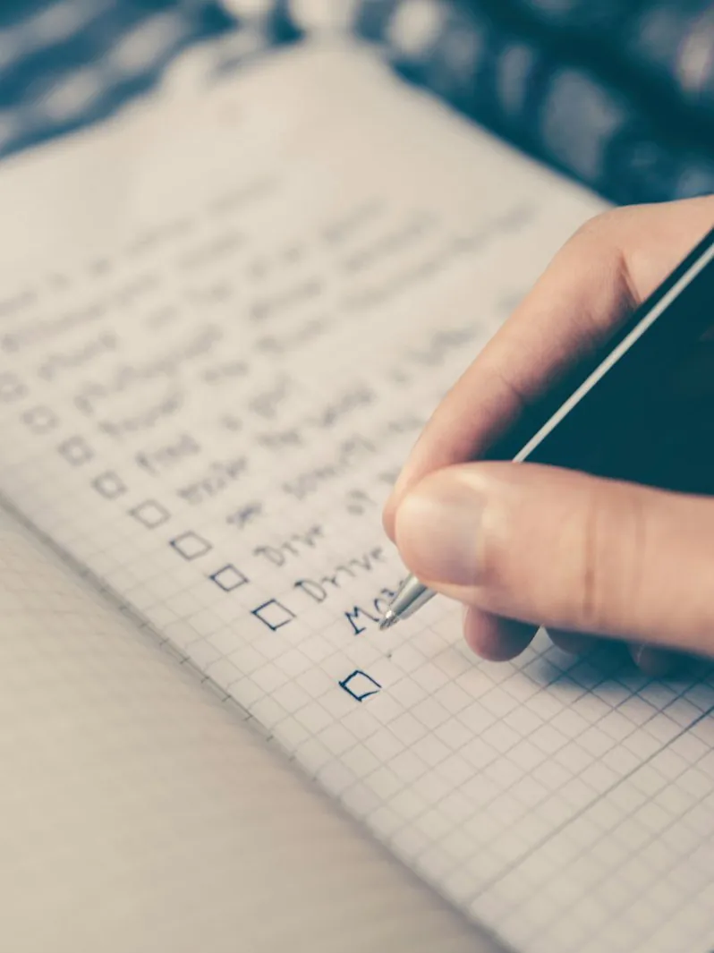 A hand ticking criteria down a list — the conditions a business must meet